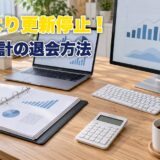 デスクに置かれたノートパソコンと電卓と帳簿